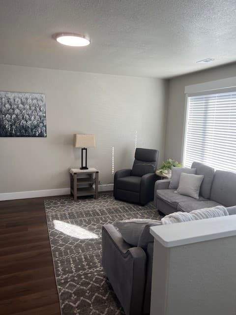 Furnished living room seating area in an extended-stay Twin Cedar apartment in Vernal, Utah